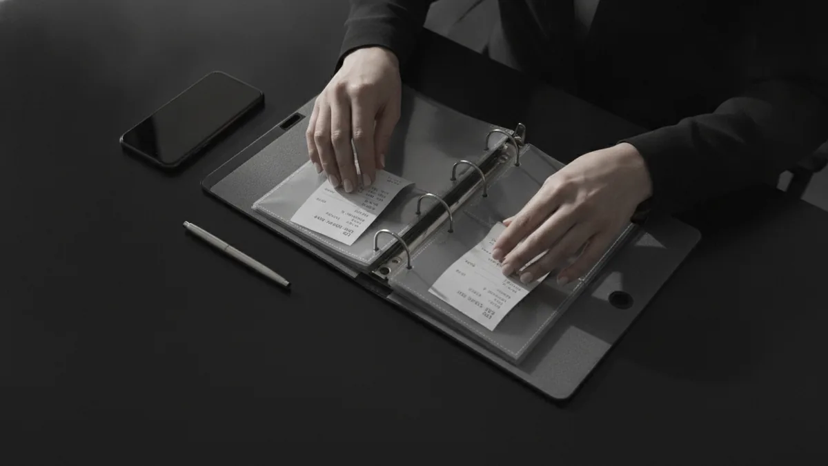 Hands organizing payment records for a settlement claim submission